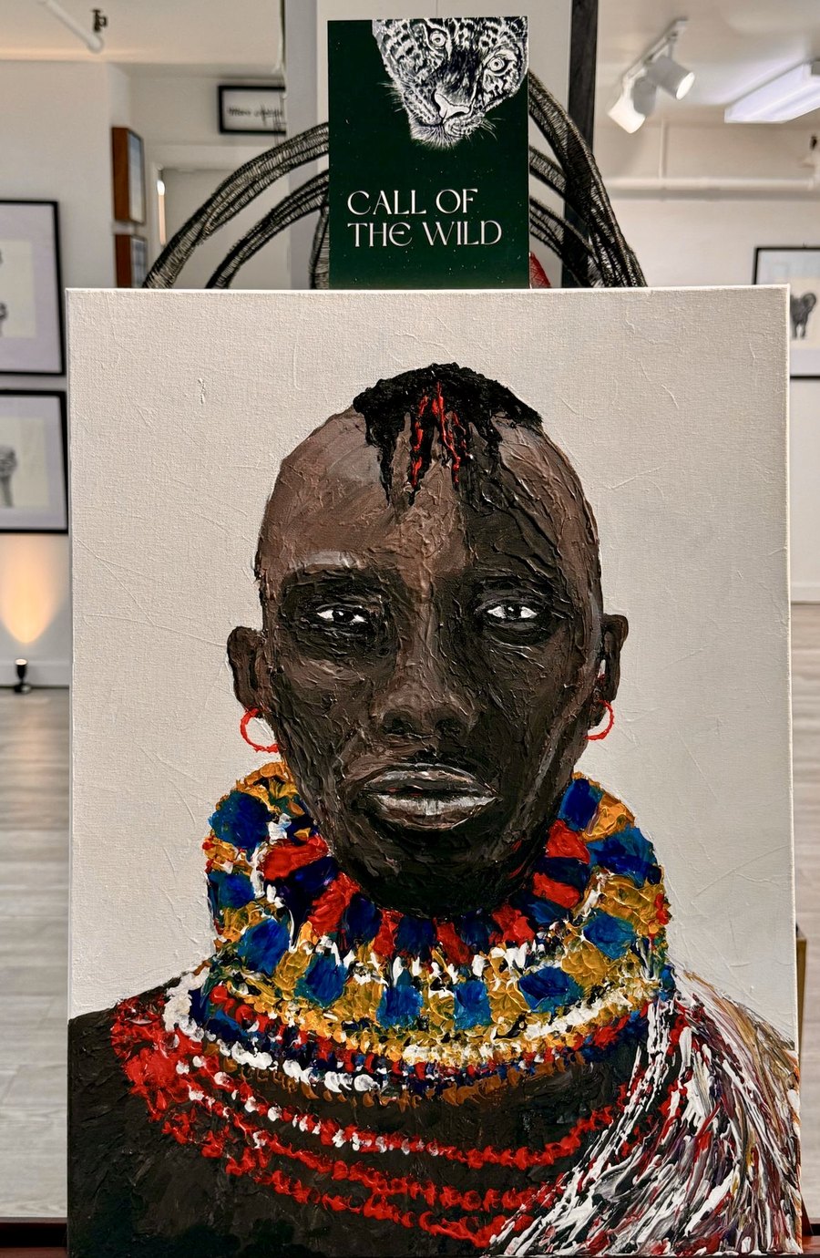 The finished Masai warrior portrait on an easel, under the Call of the Wild card
